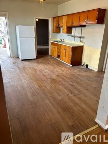 Uniontown apartment for rent - A kitchen with wooden floors and a white fridge.