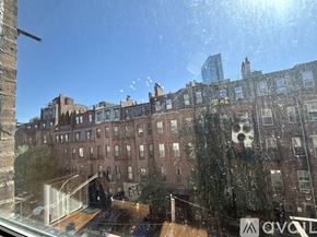 Boston apartment for rent - A view of a cityscape from a window with a reflection of a building.