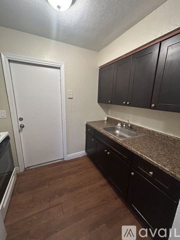 Belle Glade apartment for rent - A kitchen with black cabinets and a white door.