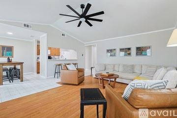 Garland house for rent - A living room with a brown leather couch and a ceiling fan.