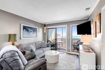 Atlantic Beach apartment for rent - A living room with a grey couch and a painting of a plane on the wall.