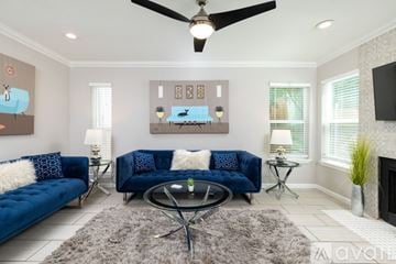 Fort Worth house for rent - A living room with a blue sofa and a glass coffee table.
