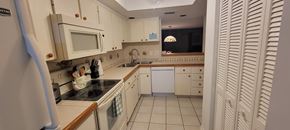 Hernando house for rent - A kitchen with white cabinets and a black stove top.