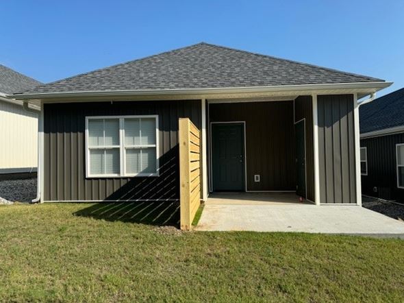 Little Rock house for rent - A house with a grey exterior and a brown wooden staircase leading to the front door.