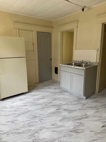 Syracuse apartment for rent - A kitchen with a marble floor and a white fridge.