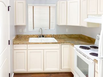 Show Low house for rent - A kitchen with white cabinets and a granite countertop.