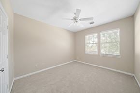 Houston house for rent - A room with a ceiling fan and two windows.