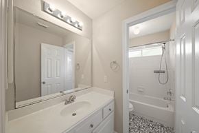 Houston house for rent - A white bathroom with a sink, mirror, and bathtub.