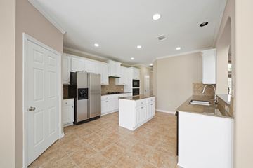 Houston house for rent - A kitchen with white cabinets and a tiled floor.