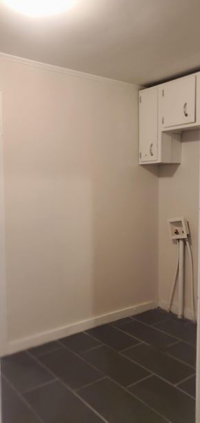 Hattiesburg house for rent - A white wall with a white electrical outlet and a white cabinet.