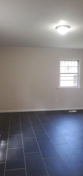 Hattiesburg house for rent - A room with a window and a tiled floor.