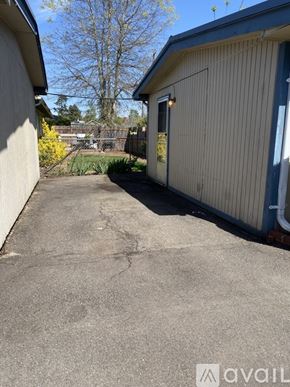 Salem apartment for rent - A concrete driveway leads to a building with a blue trim.