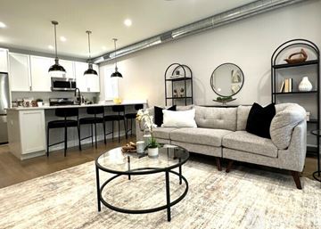 Chicago apartment for rent - A modern living room with a grey couch and a glass coffee table.