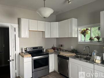 Augusta house for rent - A kitchen with white cabinets and a black stove top oven.