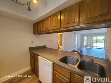 Stuart apartment for rent - A kitchen with wooden cabinets and a white dishwasher.