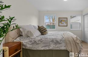 Portland house for rent - A bedroom with a large bed and a painting on the wall.
