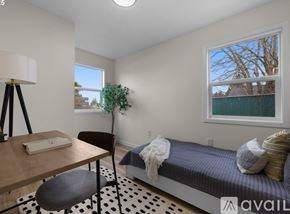 Portland house for rent - A house with a red door is surrounded by a grassy area and a tree.
