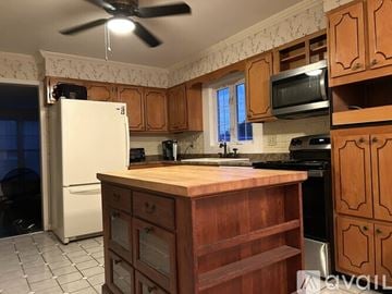 Bel Air house for rent - A kitchen with wooden cabinets and a white refrigerator.