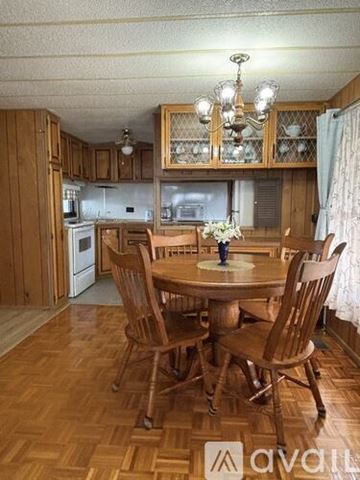 Zephyrhills house for rent - A wooden dining table with chairs and a chandelier in a kitchen.