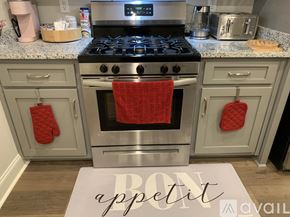Oxford house for rent - A kitchen with a stove top oven and a red towel hanging on it.