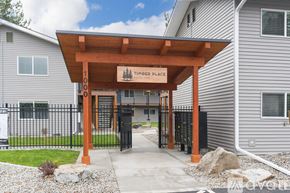 Coeur D'alene apartment for rent - A timber place sign is on a wooden structure in front of a building.
