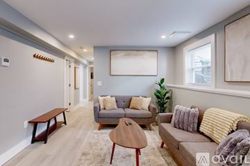 Providence apartment for rent - A living room with a grey couch, a brown coffee table, and a large painting on the wall.