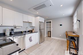 Providence apartment for rent - A kitchen with white cabinets and a black countertop.