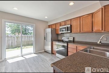 Chesapeake house for rent - A kitchen with brown cabinets and a stainless steel refrigerator.