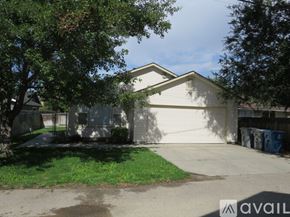 Boise townhouse for rent - A house with a garage and a tree in front.