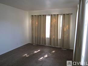 Boise townhouse for rent - A room with a carpeted floor and a window with curtains.