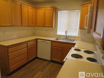 Boise townhouse for rent - A kitchen with wooden cabinets and a white dishwasher.