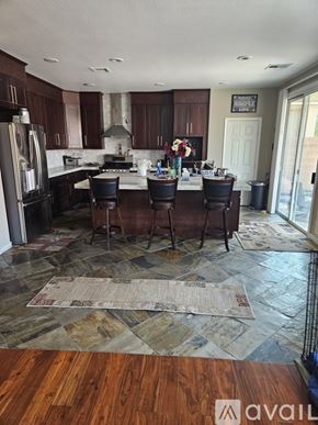 Las Vegas apartment for rent - A kitchen with a refrigerator, bar stools, and a rug on the floor.