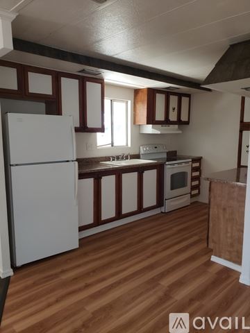 Kingman house for rent - A kitchen with wooden floors and white appliances.
