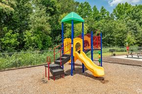 Conyers apartment for rent - A playground with a yellow slide and a green canopy.