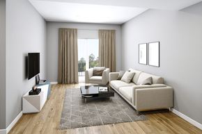 Conyers apartment for rent - A living room with a white sofa, a black TV, and a patterned rug.