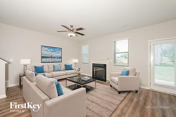 Winder house for rent - A living room with a beige couch, a fireplace, and a painting on the wall.