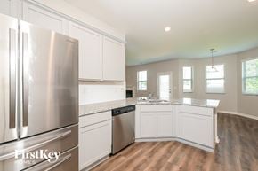 Winder house for rent - A kitchen with a stainless steel refrigerator and wooden floors.