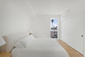 Los Angeles apartment for rent - A bedroom with a large bed and a window overlooking a tree.