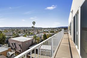 Los Angeles apartment for rent - A balcony overlooks a cityscape with buildings and trees.