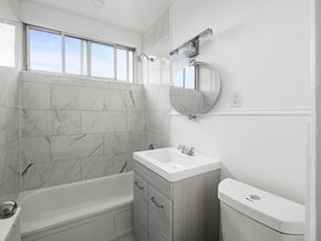 Toronto apartment for rent - A bathroom with a tub, sink, and mirror.