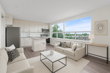 Toronto apartment for rent - A modern living room with white furniture and a large window.