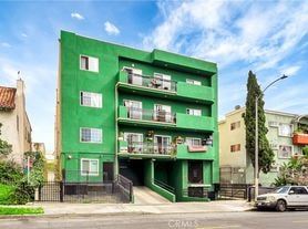 Los Angeles apartment for rent - A green building with a balcony on the second floor.