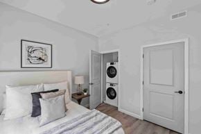East Providence apartment for rent - A bedroom with a bed, pillows, a nightstand with a lamp, and a framed picture on the wall.