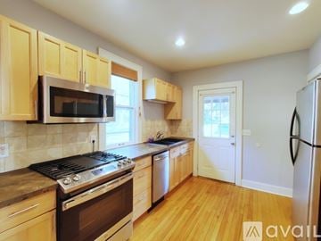 Saint Paul house for rent - A kitchen with wooden cabinets and a black stove top oven.