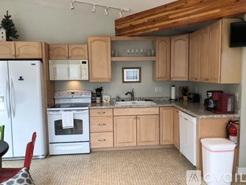 Polson condo for rent - A kitchen with wooden cabinets and a white fridge.