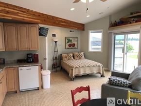 Polson condo for rent - A bedroom with a bed, a chair, and a window.