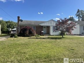 Grand Rapids house for rent - A house with a grey roof and a red tree in front.