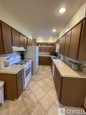 Grand Rapids house for rent - A kitchen with brown cabinets and white appliances.