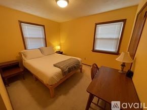 Grand Rapids house for rent - A bedroom with a bed, a table, and a chair.