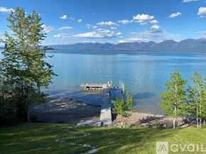Polson house for rent - A serene lake surrounded by mountains and a clear sky.